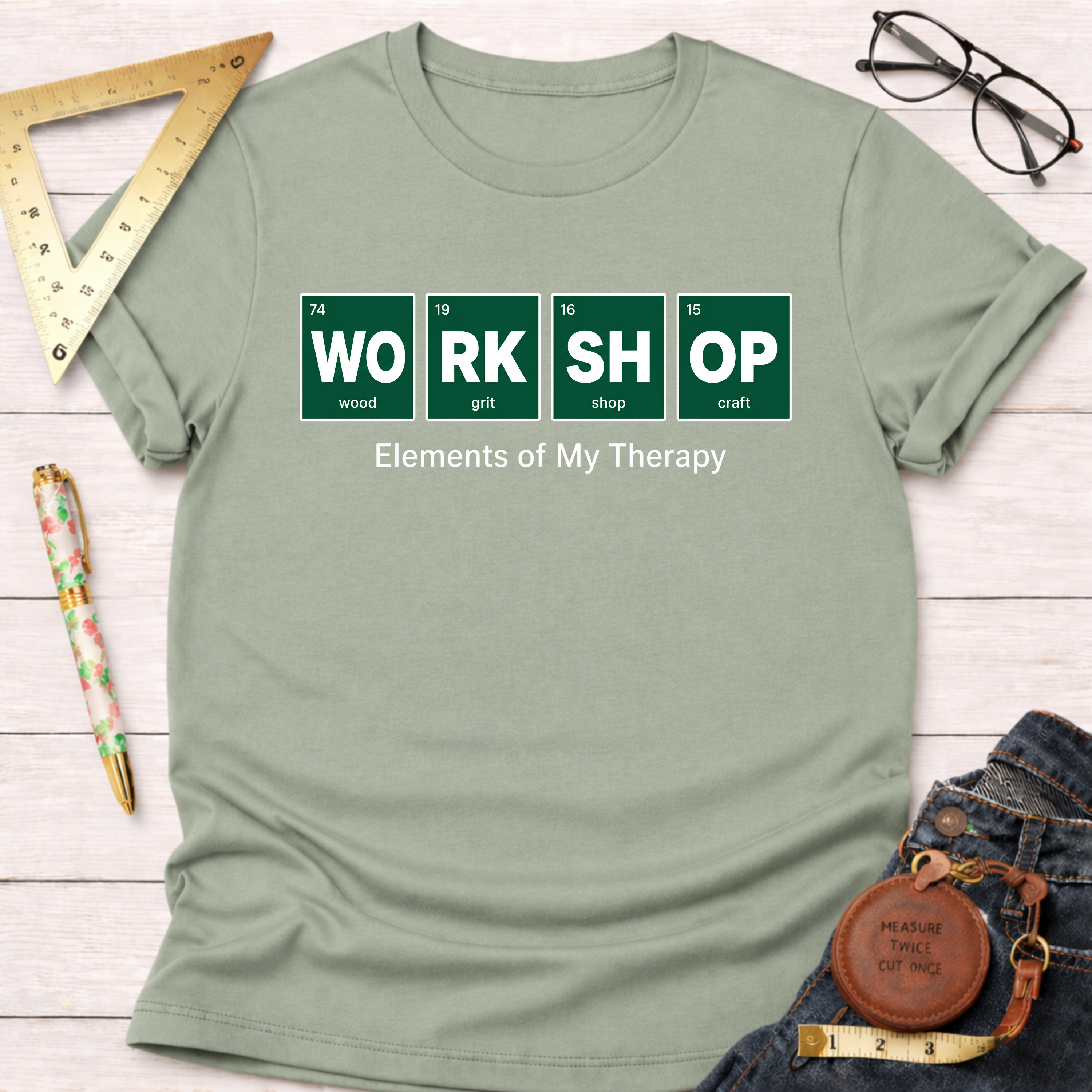Sage green "WORKSHOP Elements of My Therapy" t-shirt with periodic table design.