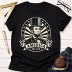 Black cotton t-shirt with a vintage-style Abraham Lincoln portrait, "America EST. 1776" banner, and flags.