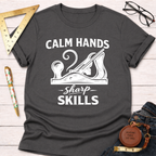 Dark gray "Calm Hands Sharp Skills" t-shirt with a hand plane graphic, styled with jeans and tools.