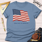 Light blue t-shirt with a waving American flag graphic and "CRAFTED IN AMERICA" text.