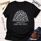 Black cotton t-shirt with "Current Status: Hiding From Society" text and a person hiding in a woodpile graphic.