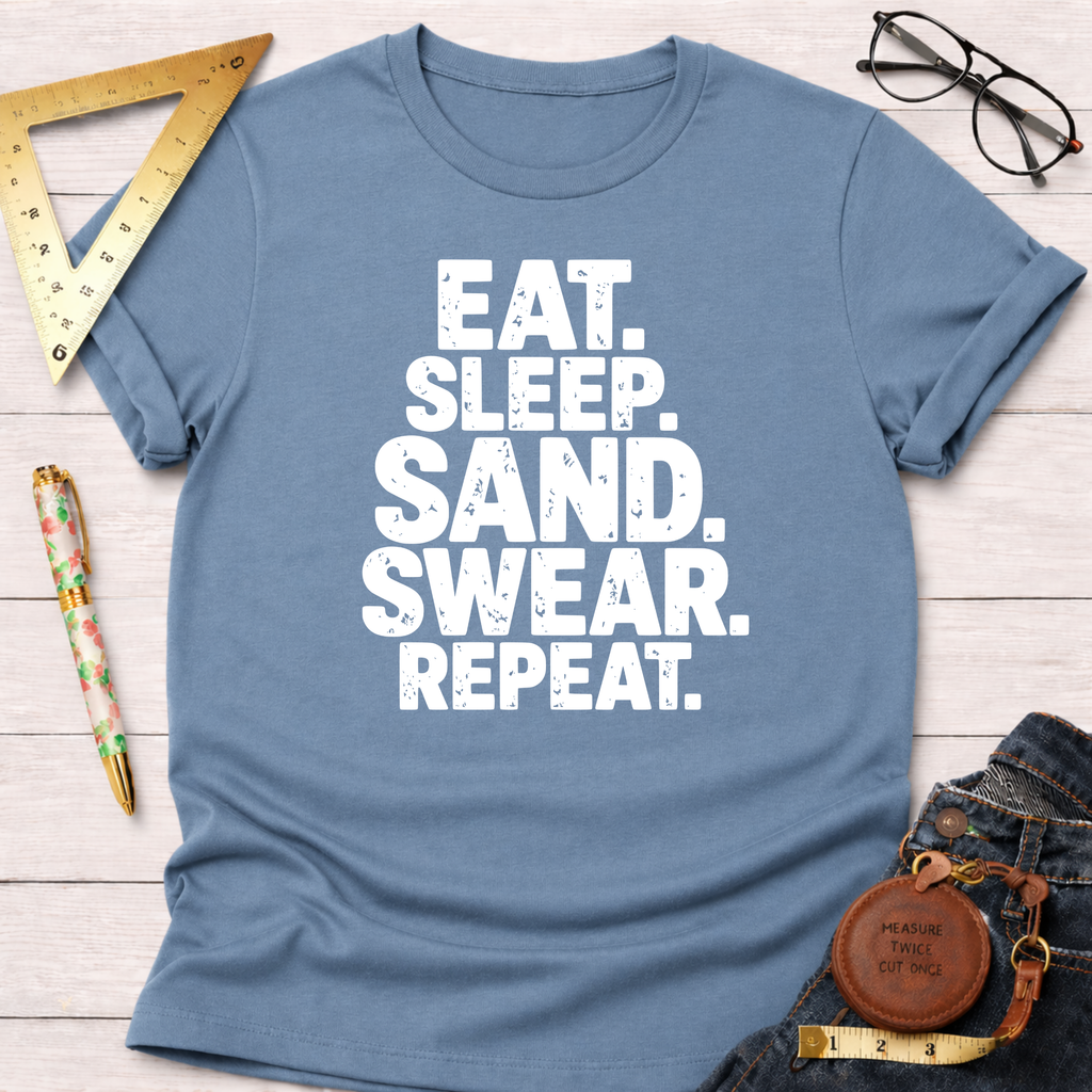Blue cotton t-shirt with "EAT. SLEEP. SAND. SWEAR. REPEAT." in white text, styled with jeans.