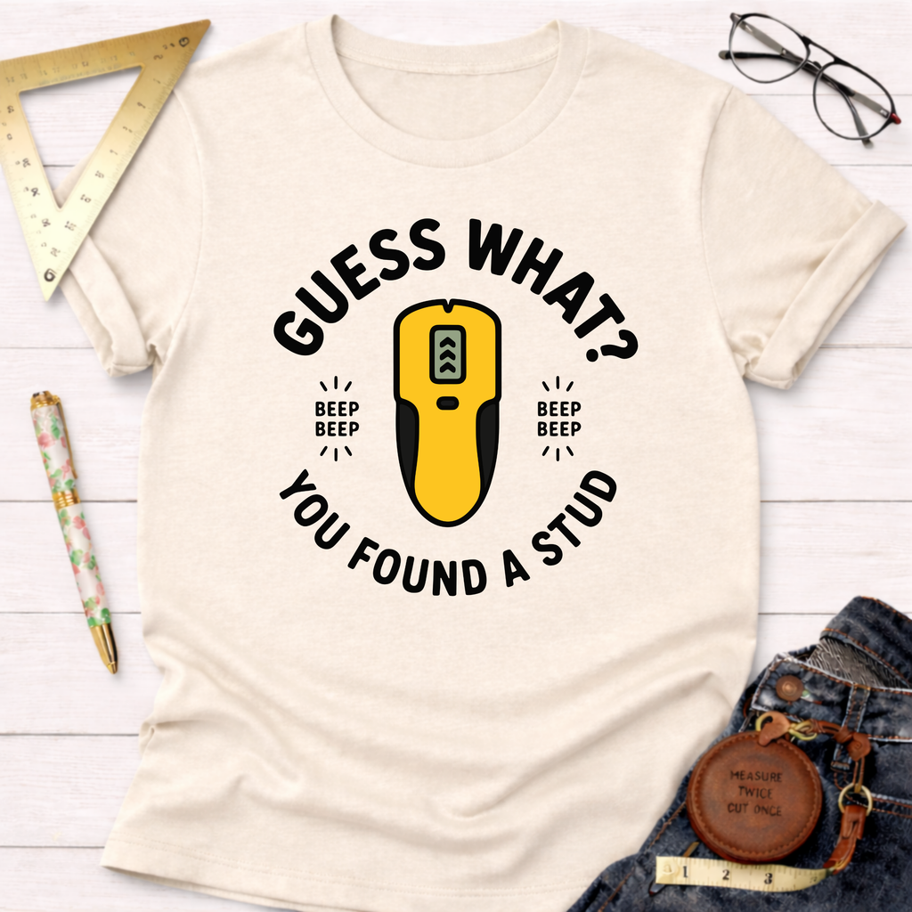 Cream t-shirt with "Guess What? You Found A Stud" text and a yellow stud finder graphic.