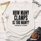 Off-white cotton t-shirt with "How Many Clamps Is Too Many? Asking for a friend." in black text.