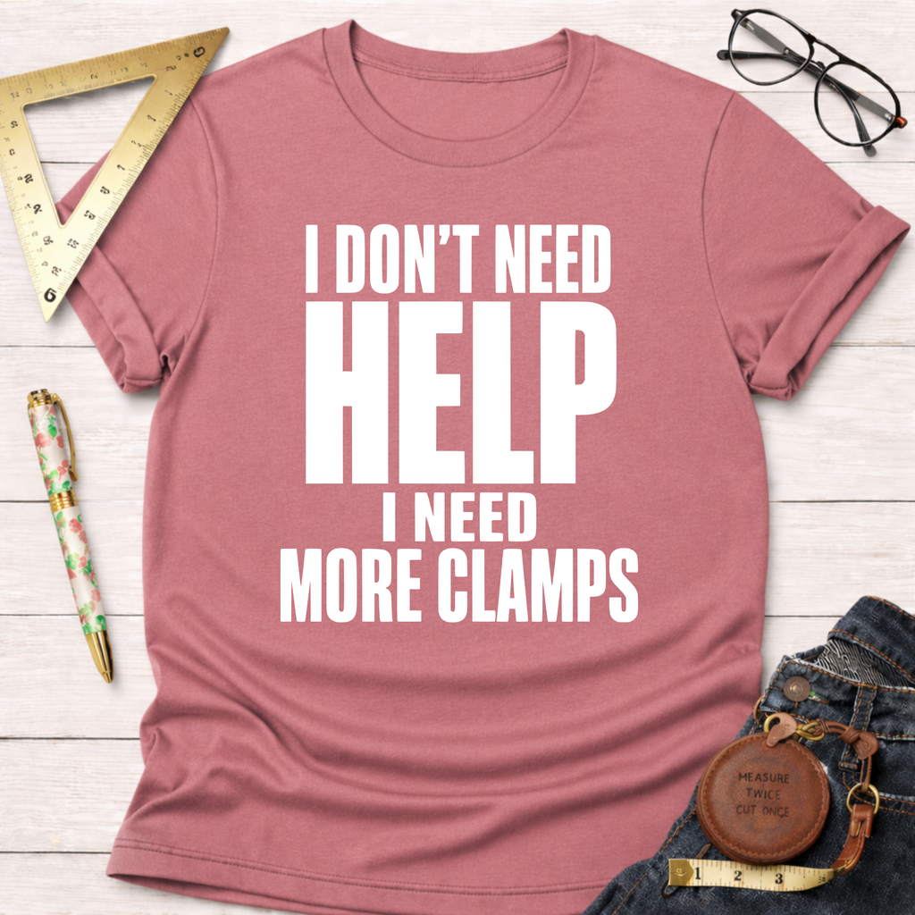 Pink unisex t-shirt with "I DON'T NEED HELP I NEED MORE CLAMPS" in white text.