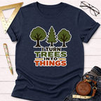 Navy blue "I Turn Trees Into Things" t-shirt with green and orange text, featuring three tree graphics.