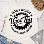 Women's funny woodworking graphic tee shirt for female woodworkers, makers, and DIY builders — Sawdust & Ponytails. White cotton t-shirt with "Don't Worry I Got This I Watched A Video Tutorial" text and saw blade graphic.