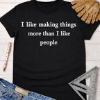 Women's funny woodworking graphic tee shirt for female woodworkers, makers, and DIY builders — Sawdust & Ponytails. Black short-sleeve tee with "I like making things more than I like people" in white text.