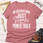 Mauve pink t-shirt with "NO INSTRUCTIONS JUST Vibes AND POWER TOOLS" in white text.