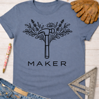 Women's funny woodworking graphic tee shirt for female woodworkers, makers, and DIY builders — Sawdust & Ponytails. Blue cotton tee with black floral hammer "MAKER" graphic.