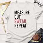 Off-white cotton t-shirt with "MEASURE CUT SWEAR REPEAT" graphic, surrounded by woodworking tools.