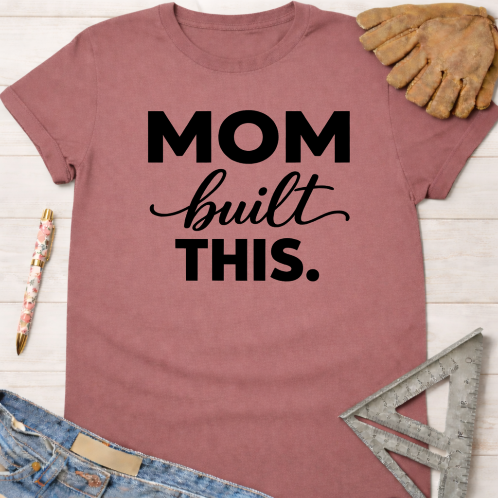 Women's funny woodworking graphic tee shirt for female woodworkers, makers, and DIY builders — Sawdust & Ponytails. Mauve t-shirt with "MOM built THIS." in black text.