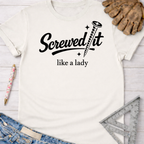 Women's funny woodworking graphic tee shirt for female woodworkers, makers, and DIY builders — Sawdust & Ponytails. Cream t-shirt with "Screwed it like a lady" text and screw graphic.