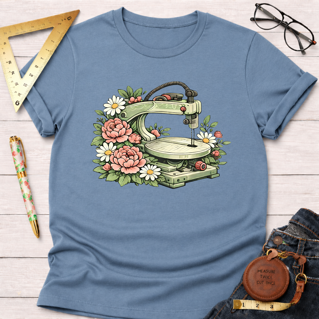 Blue t-shirt with a scroll saw illustration surrounded by pink peonies and white daisies.