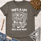 Women's funny woodworking graphic tee shirt for female woodworkers, makers, and DIY builders — Sawdust & Ponytails. Dark gray cotton tee with "She's A Lot. She's Also Right." and a cartoon yak at a workbench.