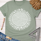 Women's funny woodworking graphic tee shirt for female woodworkers, makers, and DIY builders — Sawdust & Ponytails. Sage green t-shirt with a white tree ring of life design, surrounded by deer, mountains, and mushrooms.