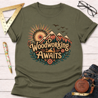 Olive green cotton t-shirt with "Woodworking Awaits" graphic featuring mountains, a saw sun, and flowers.