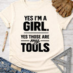 Women's funny woodworking graphic tee shirt for female woodworkers, makers, and DIY builders — Sawdust & Ponytails. Cream t-shirt with "YES I'M A GIRL. YES THOSE ARE MY TOOLS" in black text.