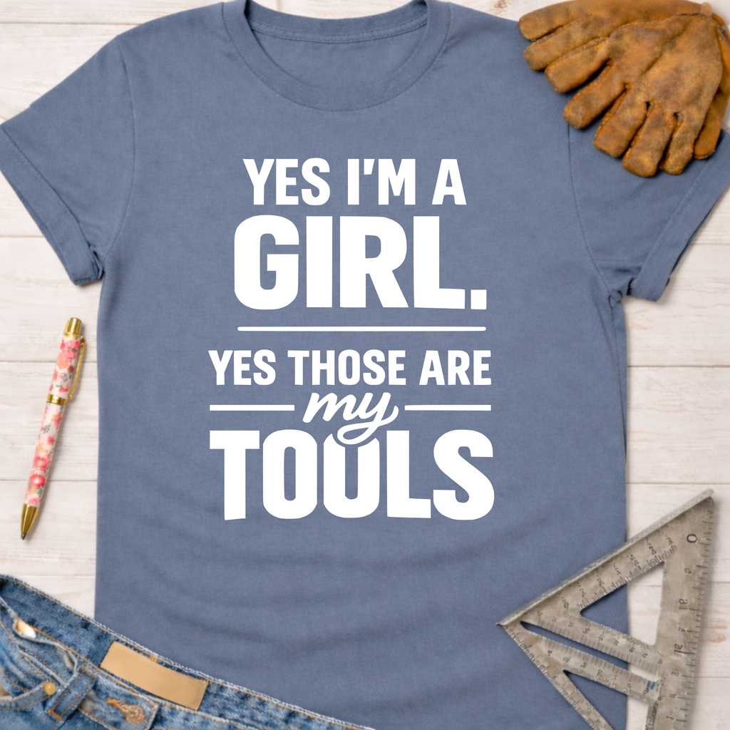 Women's funny woodworking graphic tee shirt for female woodworkers, makers, and DIY builders — Sawdust & Ponytails. Blue cotton tee with "YES I'M A GIRL. YES THOSE ARE MY TOOLS" in white text.