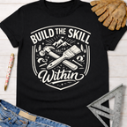 Black cotton "Build the Skill Within" graphic tee with hammer, paintbrush, and mountains. Women's funny woodworking graphic tee shirt for female woodworkers, makers, and DIY builders — Sawdust & Ponytails