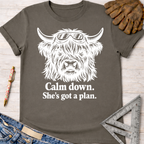 Women's funny woodworking graphic tee shirt for female woodworkers, makers, and DIY builders — Sawdust & Ponytails. Dark gray cotton tee with a white graphic of a Highland cow in safety goggles and text "Calm down. She's got a plan.