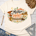 Women's funny woodworking graphic tee shirt for female woodworkers, makers, and DIY builders — Sawdust & Ponytails. Cream t-shirt with "Maker at Heart: Crafting My Own Path" graphic, tools, and nature.