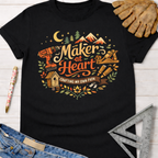 Black cotton Women's funny woodworking graphic tee shirt for female woodworkers, makers, and DIY builders — Sawdust & Ponytails, featuring "Maker at Heart: Crafting My Own Path" design with tools, mountains, and trees.