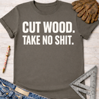 Women's funny woodworking graphic tee shirt for female woodworkers, makers, and DIY builders — Sawdust & Ponytails. Dark gray cotton t-shirt with "CUT WOOD. TAKE NO SHIT." in white text.