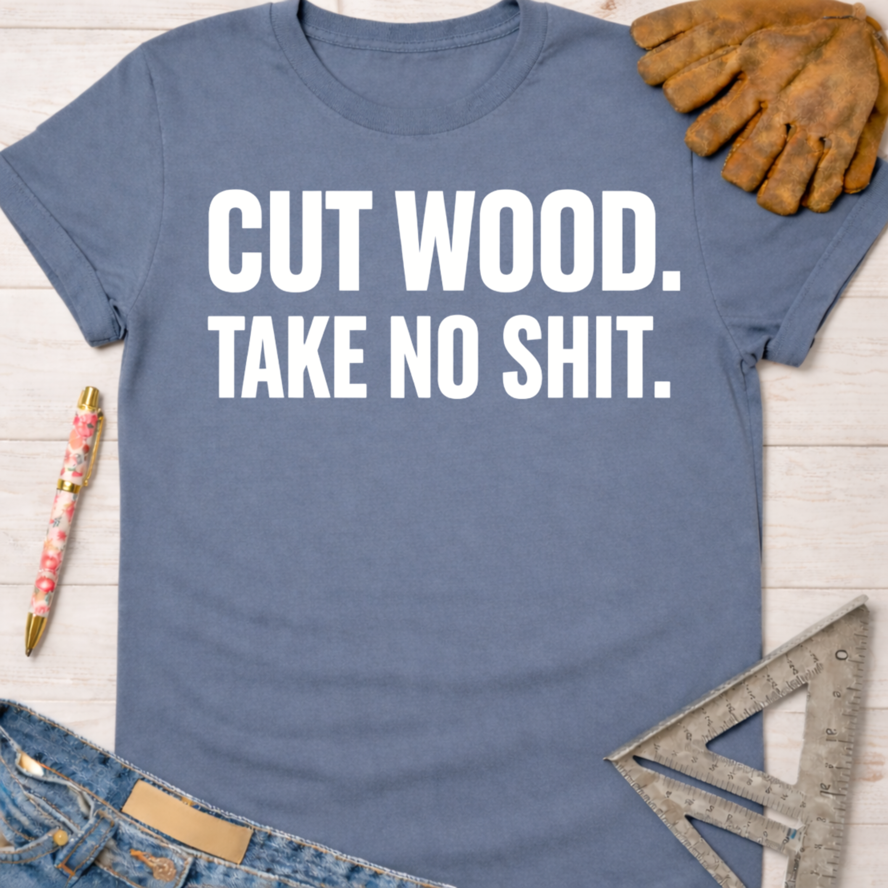 Women's funny woodworking graphic tee shirt for female woodworkers, makers, and DIY builders — Sawdust & Ponytails. Blue cotton tee with "CUT WOOD. TAKE NO SHIT." in white text.