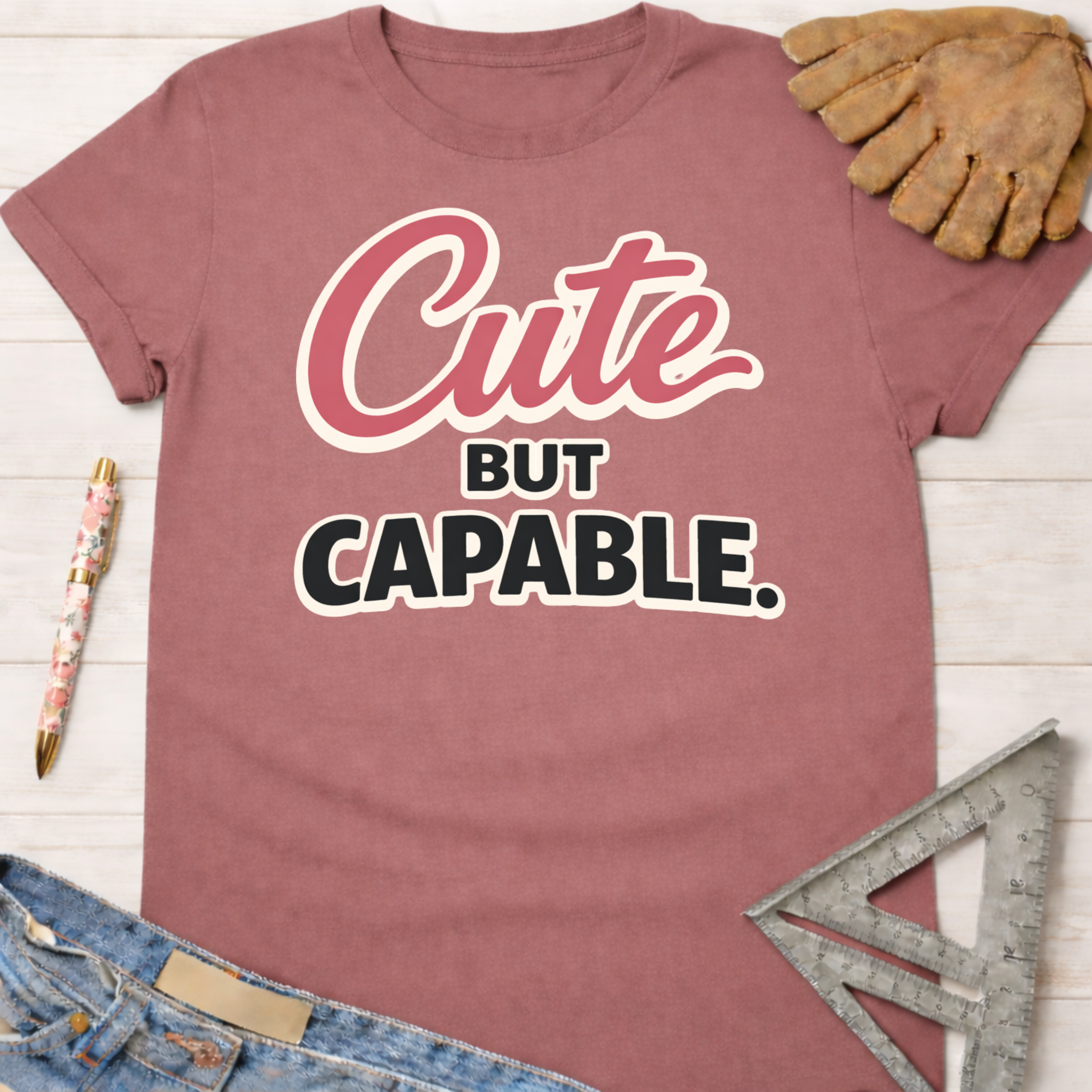 Women's funny woodworking graphic tee shirt for female woodworkers, makers, and DIY builders — Sawdust & Ponytails. Mauve cotton tee with "Cute BUT CAPABLE." text.