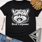 Black Feral Carpenter T-shirt with a raccoon wearing sunglasses graphic. Women's funny woodworking graphic tee shirt for female woodworkers, makers, and DIY builders — Sawdust & Ponytails.