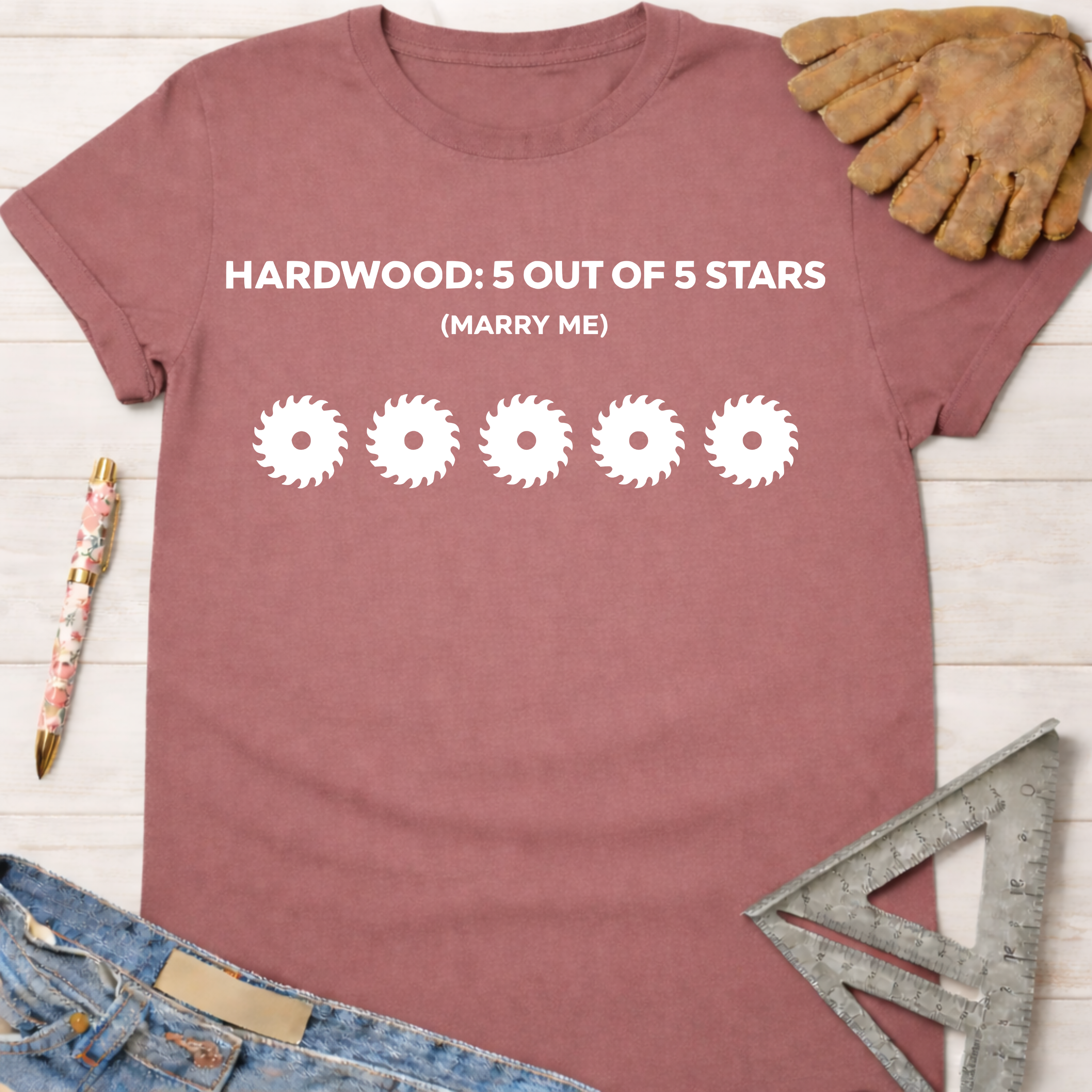 Women's funny woodworking graphic tee shirt for female woodworkers, makers, and DIY builders — Sawdust & Ponytails. Mauve cotton tee with "HARDWOOD: 5 OUT OF 5 STARS (MARRY ME)" and five saw blade graphics.