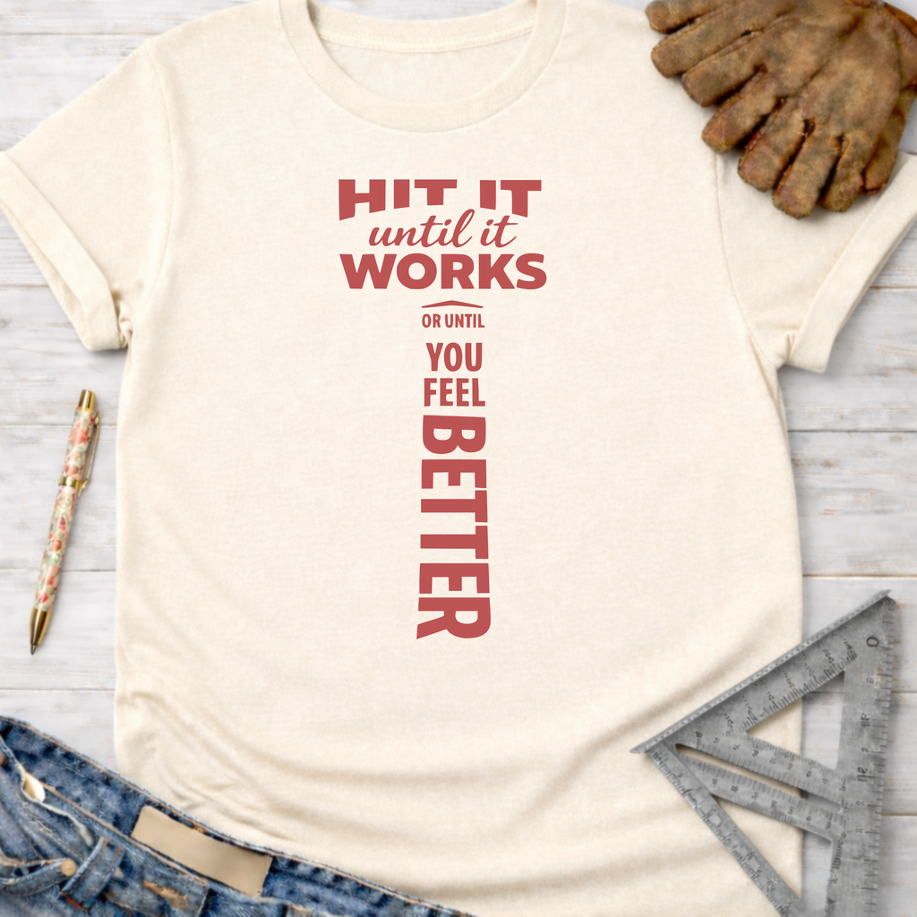 Women's funny woodworking graphic tee shirt for female woodworkers, makers, and DIY builders — Sawdust & Ponytails. Cream t-shirt with "HIT IT until it WORKS OR UNTIL YOU FEEL BETTER" in red, shaped like a hammer.