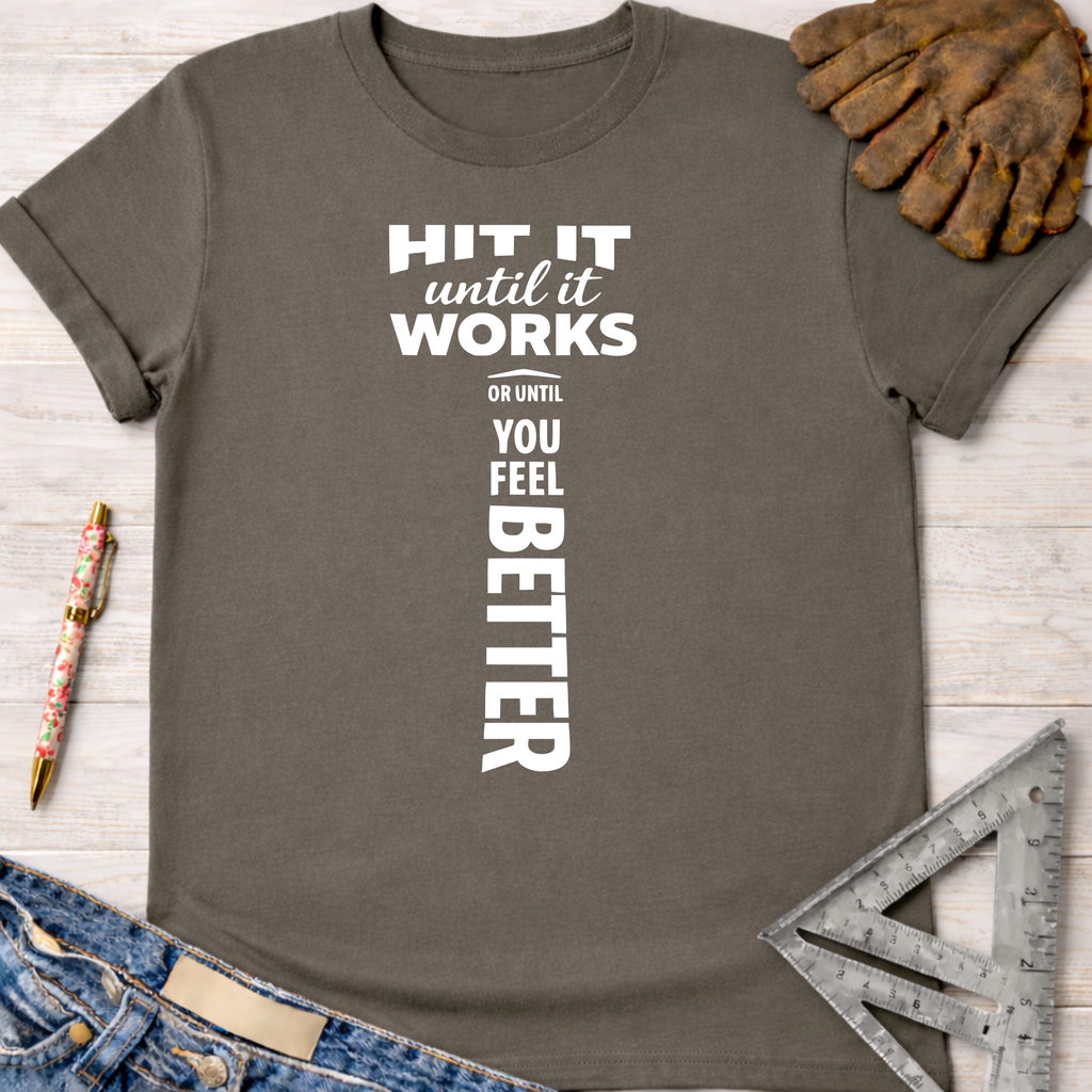 Women's funny woodworking graphic tee shirt for female woodworkers, makers, and DIY builders — Sawdust & Ponytails. Charcoal gray cotton t-shirt with "HIT IT until it works OR UNTIL YOU FEEL BETTER" in white text, styled like a hammer.