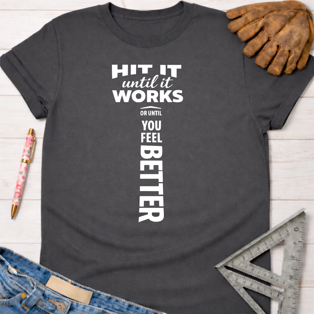 Women's funny woodworking graphic tee shirt for female woodworkers, makers, and DIY builders — Sawdust & Ponytails. Dark gray cotton tee with "Hit It Until It Works Or Until You Feel Better" text.