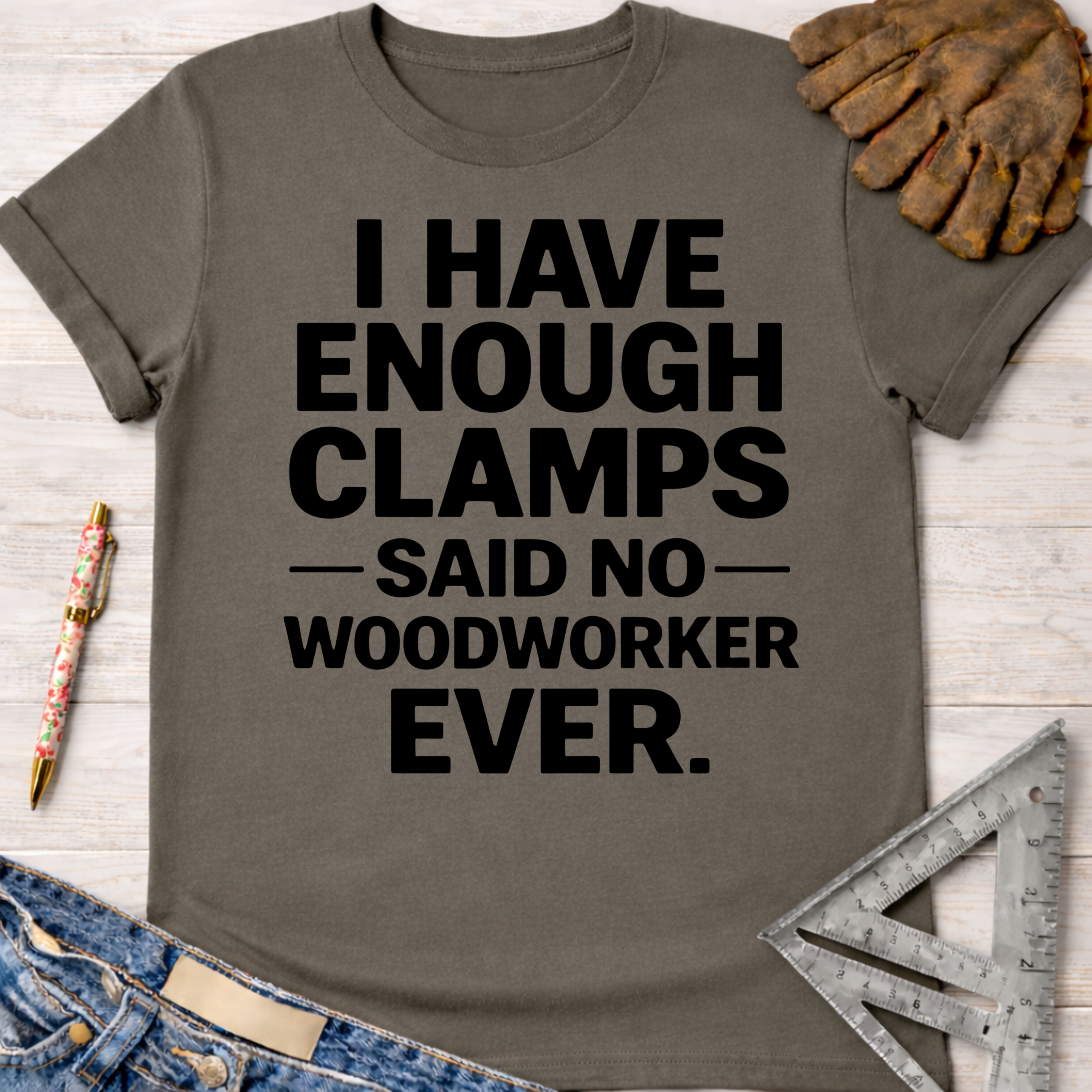 Women's funny woodworking graphic tee shirt for female woodworkers, makers, and DIY builders — Sawdust & Ponytails. Dark gray cotton t-shirt with "I HAVE ENOUGH CLAMPS — SAID NO — WOODWORKER EVER." in black text.
