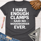 Women's funny woodworking graphic tee shirt for female woodworkers, makers, and DIY builders — Sawdust & Ponytails. Dark gray cotton t-shirt with "I HAVE ENOUGH CLAMPS -SAID NO- WOODWORKER EVER." in white text.
