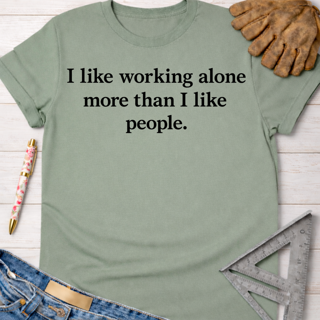 Women's funny woodworking graphic tee shirt for female woodworkers, makers, and DIY builders — Sawdust & Ponytails. Sage green cotton t-shirt with "I like working alone more than I like people" text.