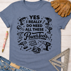Women's funny woodworking graphic tee shirt for female woodworkers, makers, and DIY builders — Sawdust & Ponytails. Blue cotton tee with "YES I REALLY DO NEED ALL THESE Power Tools" graphic.