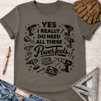 Women's funny woodworking graphic tee shirt for female woodworkers, makers, and DIY builders — Sawdust & Ponytails. Dark gray cotton tee with "YES I REALLY DO NEED ALL THESE Power Tools" and tool illustrations.