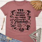 Women's funny woodworking graphic tee shirt for female woodworkers, makers, and DIY builders — Sawdust & Ponytails. Mauve t-shirt with "YES I REALLY DO NEED ALL THESE Power Tools" and tool graphics.