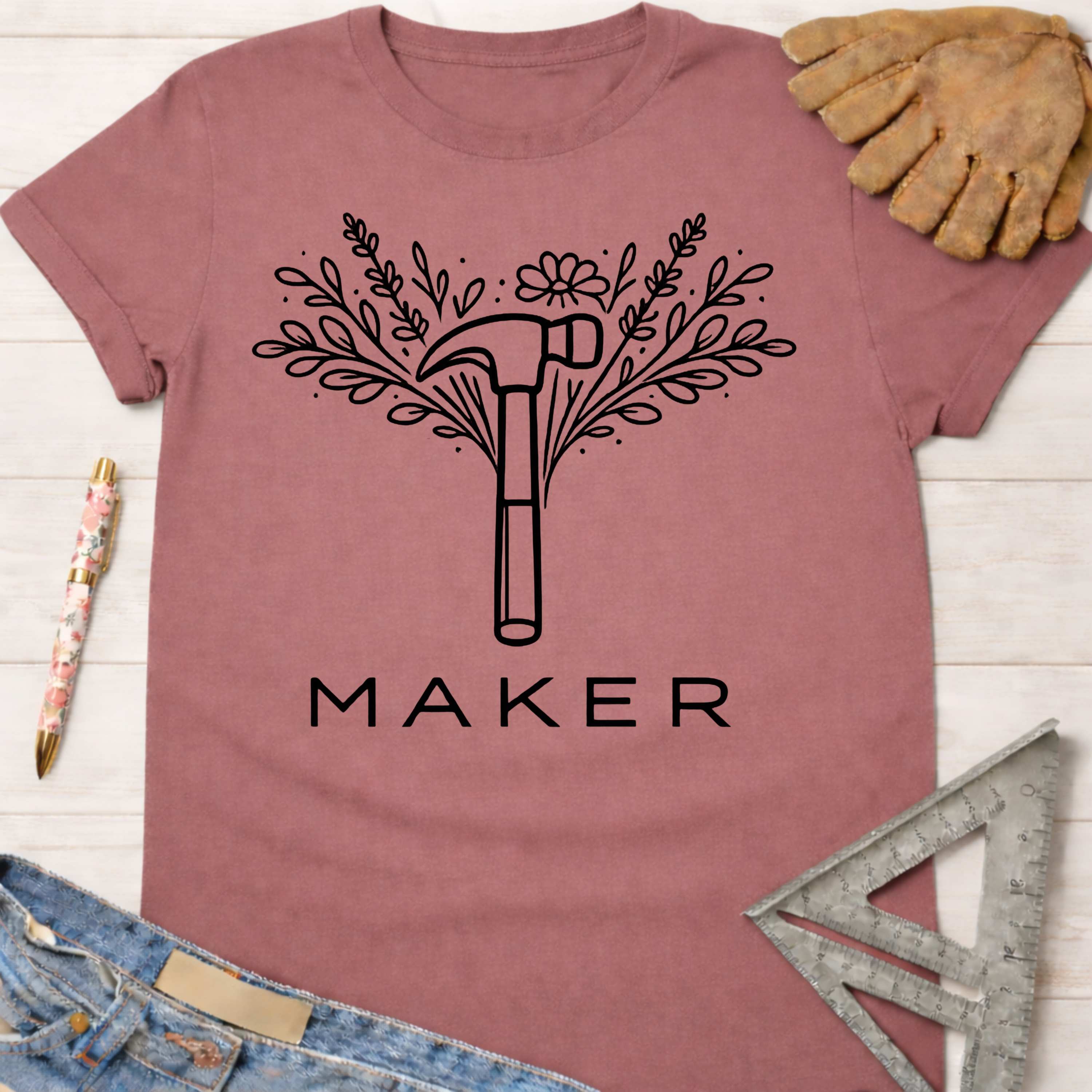 Women's funny woodworking graphic tee shirt for female woodworkers, makers, and DIY builders — Sawdust & Ponytails. Mauve cotton tee with a black floral hammer and "MAKER" graphic.