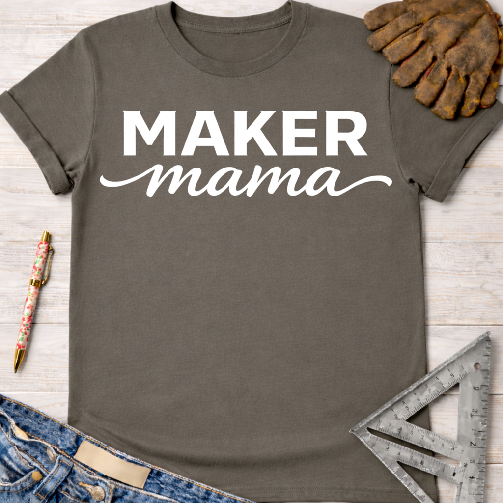 Women's funny woodworking graphic tee shirt for female woodworkers, makers, and DIY builders — Sawdust & Ponytails. Dark gray short-sleeve t-shirt with "MAKER mama" in white text.