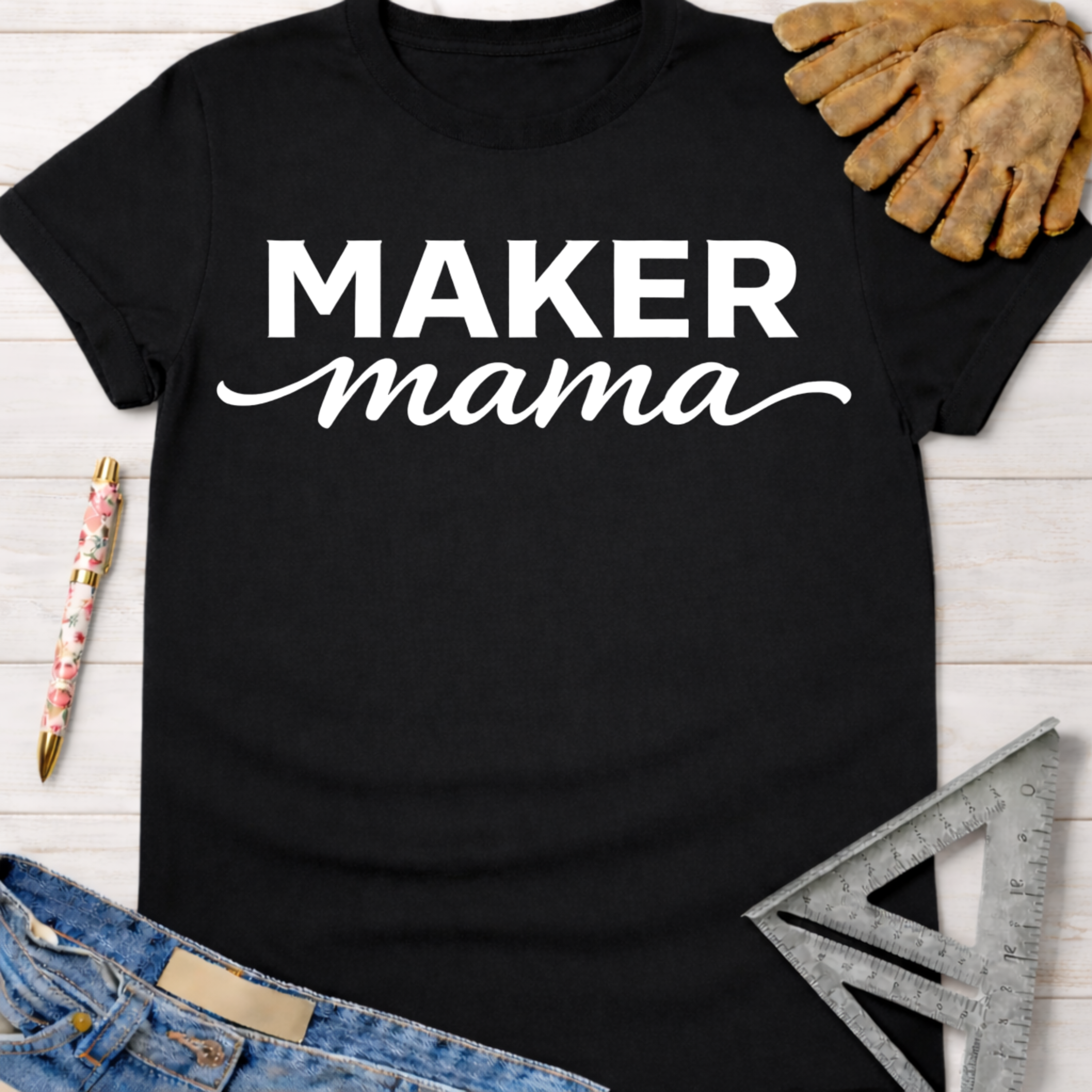 Black cotton "MAKER mama" graphic tee with work glove, jeans, pen, and square ruler. Women's funny woodworking graphic tee shirt for female woodworkers, makers, and DIY builders — Sawdust & Ponytails