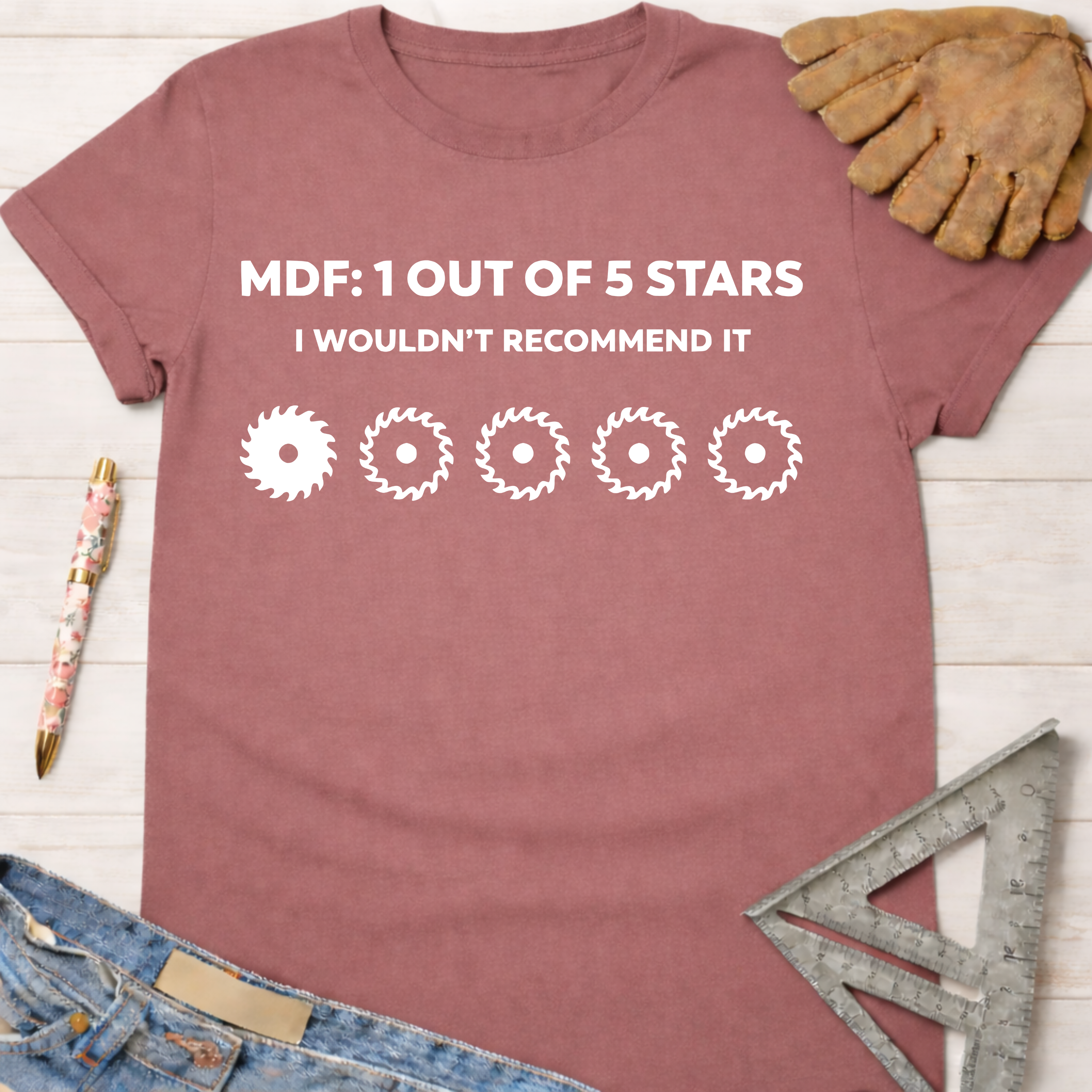 Women's funny woodworking graphic tee shirt for female woodworkers, makers, and DIY builders — Sawdust & Ponytails. Mauve t-shirt with "MDF: 1 Out Of 5 Stars I Wouldn't Recommend It" and saw blade graphics.