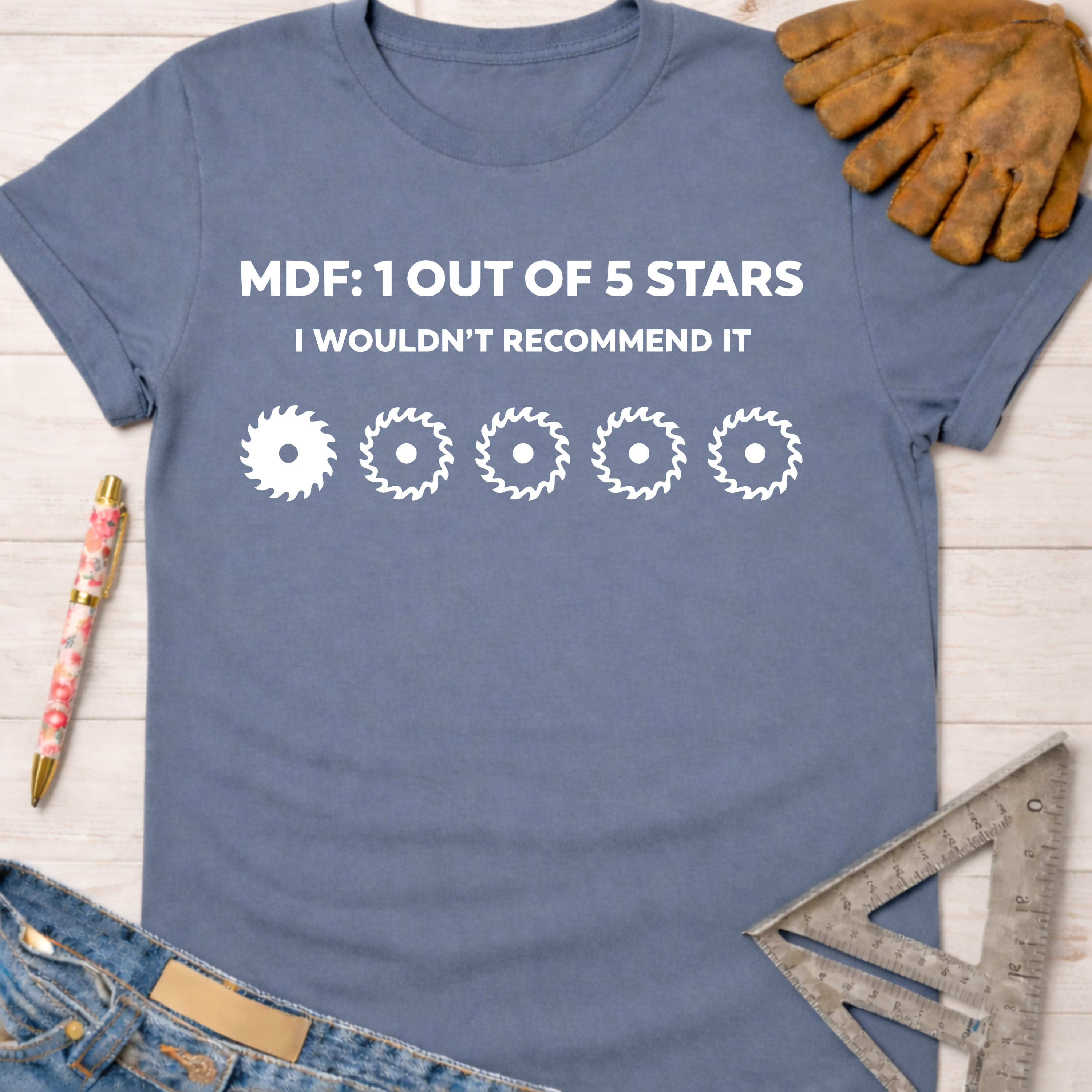 Women's funny woodworking graphic tee shirt for female woodworkers, makers, and DIY builders — Sawdust & Ponytails. Blue cotton t-shirt with "MDF: 1 OUT OF 5 STARS I WOULDN'T RECOMMEND IT" text and saw blade graphic.
