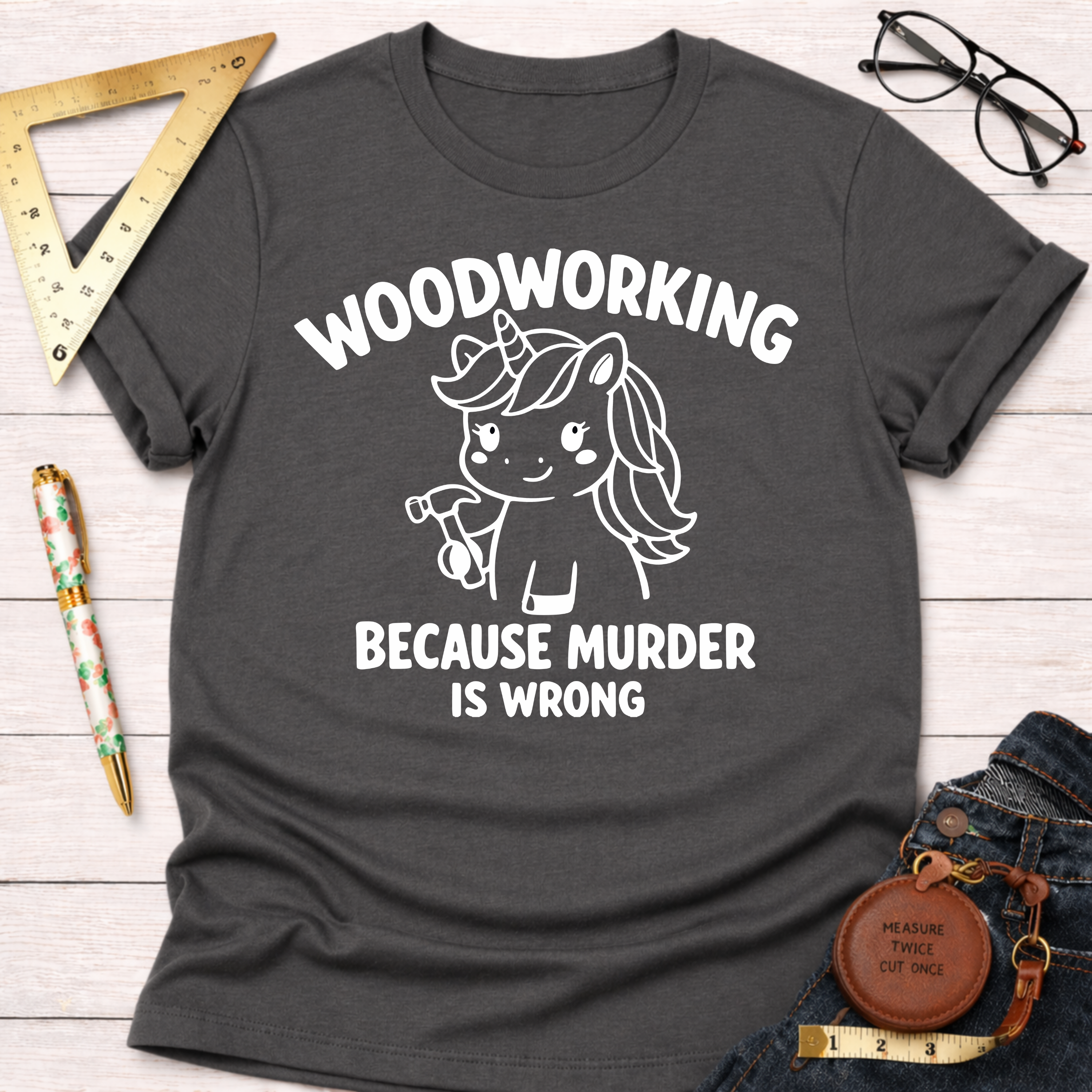 Charcoal gray women's funny woodworking graphic tee with a unicorn holding a hammer and "Woodworking Because Murder Is Wrong" text.