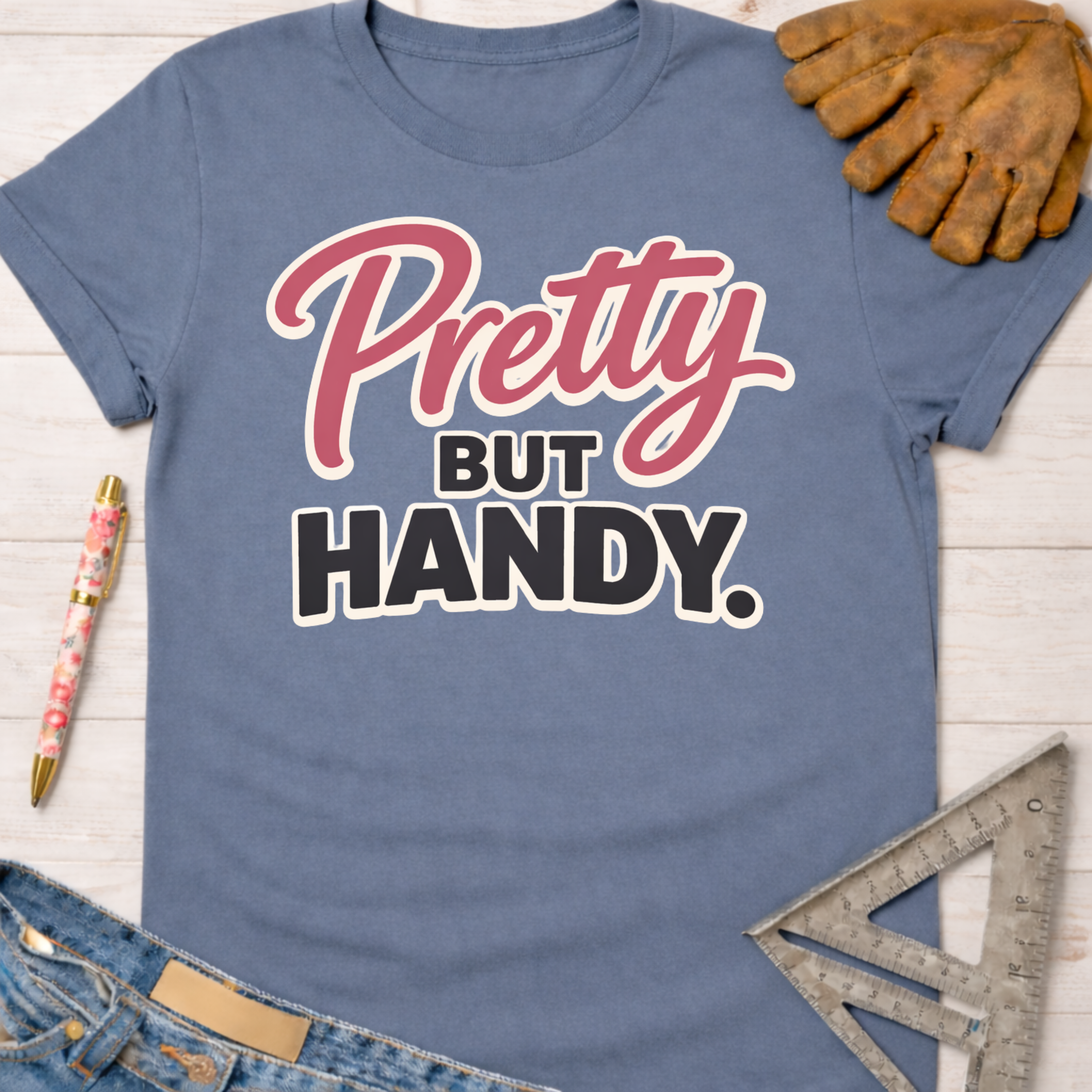 Women's funny woodworking graphic tee shirt for female woodworkers, makers, and DIY builders — Sawdust & Ponytails. Blue cotton tee with "Pretty But Handy" in pink and black.