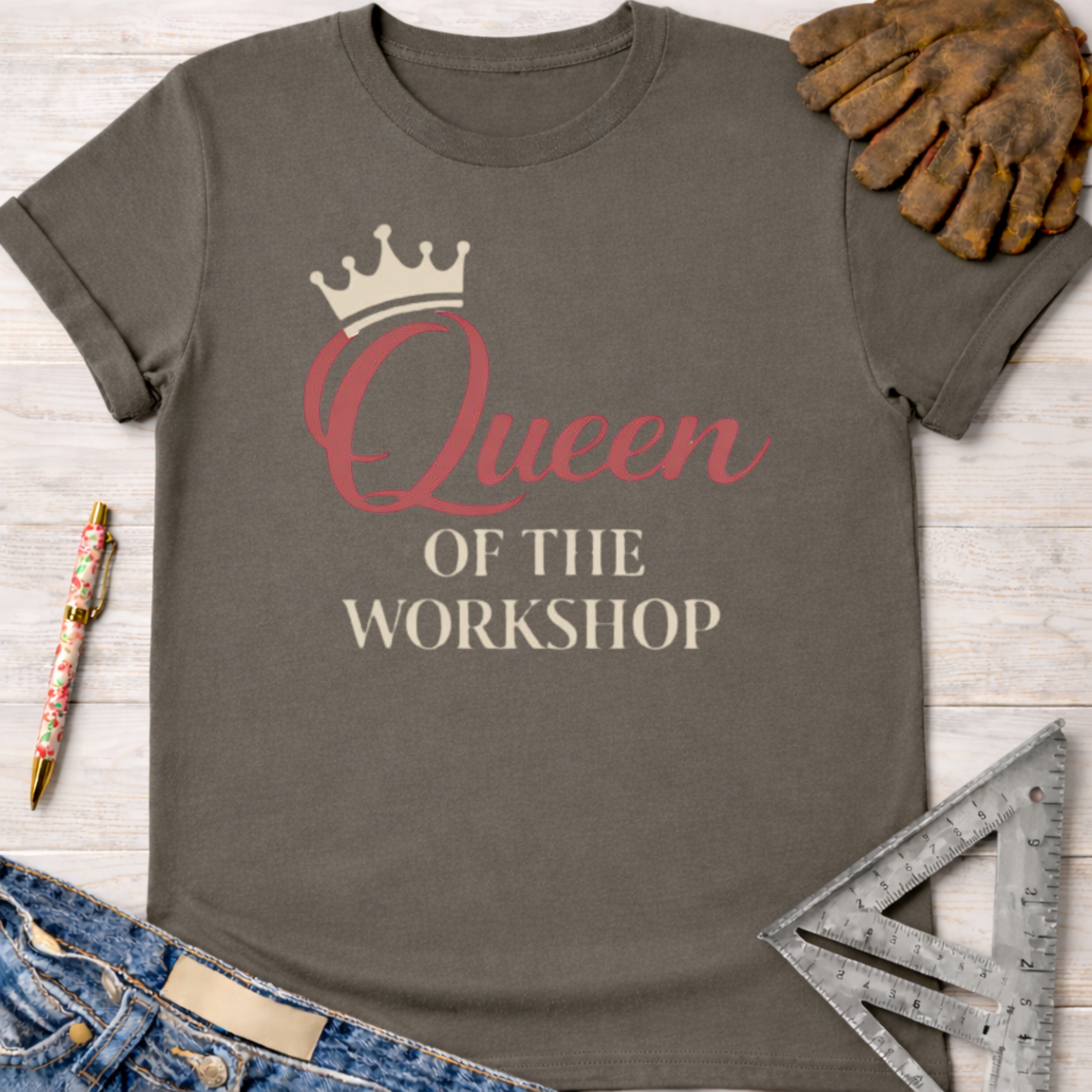 Women's funny woodworking graphic tee shirt for female woodworkers, makers, and DIY builders — Sawdust & Ponytails. Dark gray cotton tee with "Queen OF THE WORKSHOP" text and a crown graphic.
