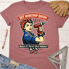 Women's funny woodworking graphic tee shirt for female woodworkers, makers, and DIY builders — Sawdust & Ponytails. Mauve short-sleeve tee with "DIY Workshop Queen!" Rosie the Riveter holding a drill, and "Build It! Fix It! Do It Yourself!" text.